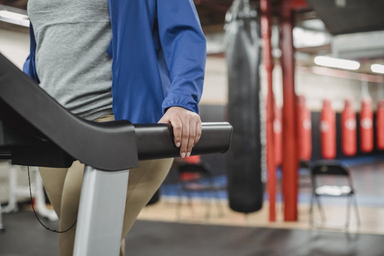 A curvy woman exercises on a treadmill in a modern gym setting, showcasing fitness and motivation.